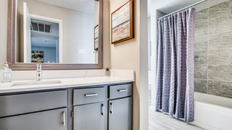 a bathroom with a shower and sink and a mirror at The  Durham